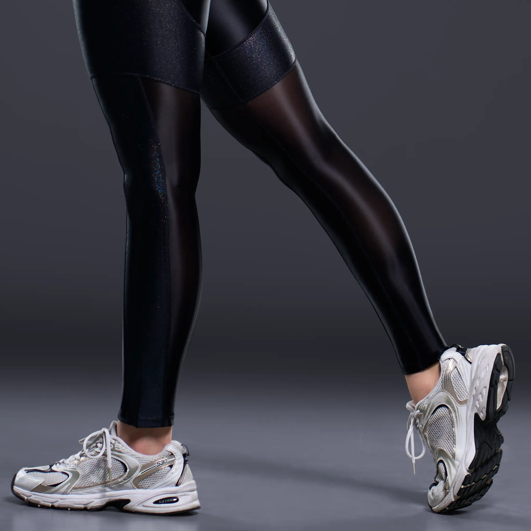 Close-up of black Ultra Rush leggings with sheer nylon inserts and flowing seam construction.